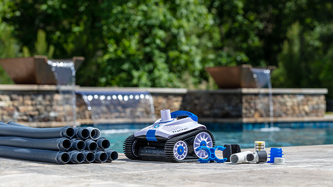 Trac Vac Pool Cleaner by the side of a pool with it's parts.